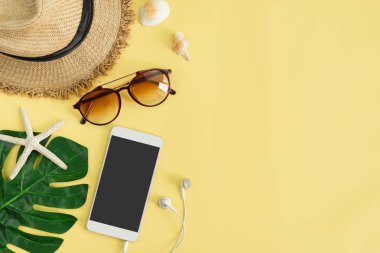 Sarı arka planda akıllı telefon ile seyahat aksesuarları öğeleri, 