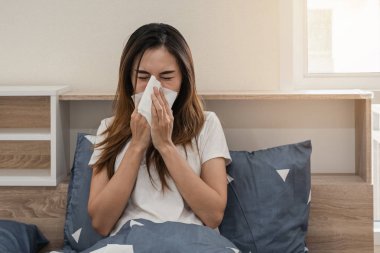 Asya kadın duygu hasta ve hapşırma üzerinde the yatak