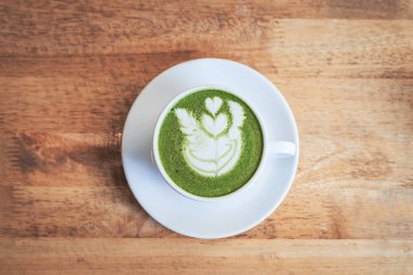 Ahşap arka plan üzerine bir fincan yeşil çay Matcha latte