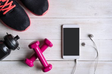Beyaz ahşap ba boş ekran akıllı telefon ile spor ekipmanları