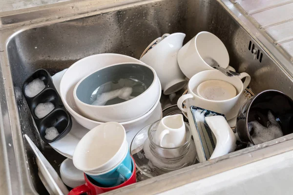 Pile of dishes and plates in sink