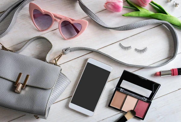 Woman accessories with make up, cosmetics, brush and smart phone