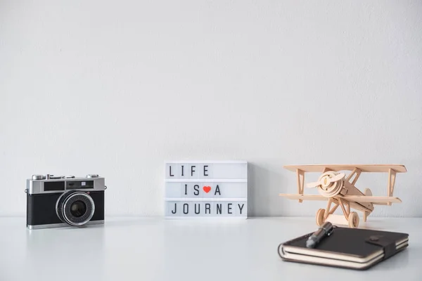 Retro camera with toy plane and notebook with copy space, Travel