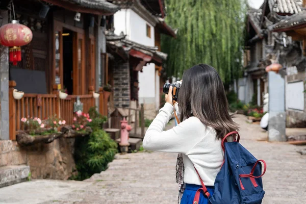 Jovem viajante caminhando e fotografando em Lijiang velho para — Fotografia de Stock