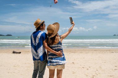 Tropik plajda selfie çekmek için sevgi dolu çift gezgin