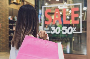 Kara Cuma günü alışveriş merkezinde alışveriş poşetleri ile genç kadın, Kadın li
