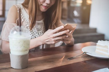 Akıllı telefon kullanan ve kafede pasta yiyen genç kadın, Kadın lif