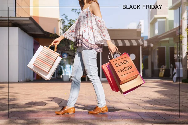 Jonge vrouw met boodschappentassen in winkelcentrum op Black Friday, — Stockfoto