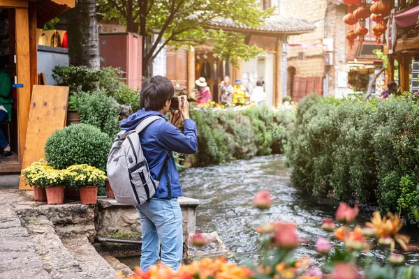 Jovem viajante caminhando e fotografando na cidade velha de Lijiang em — Fotografia de Stock