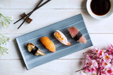 Beyaz ahşap masada soya soslu saşimi suşi seti.