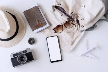 Boş ekran akıllı telefonu seyahat aksesuarları ve beyaz arkaplanda kopya alanı, seyahat planlama kavramı olan ögeler