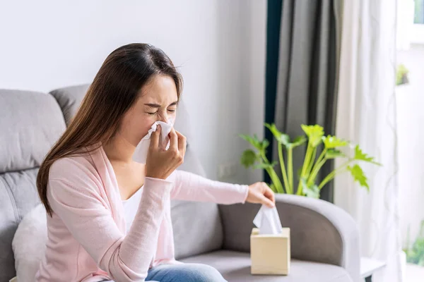 使用组织和在家里打喷嚏时感到过敏的亚洲年轻妇女 — 图库照片