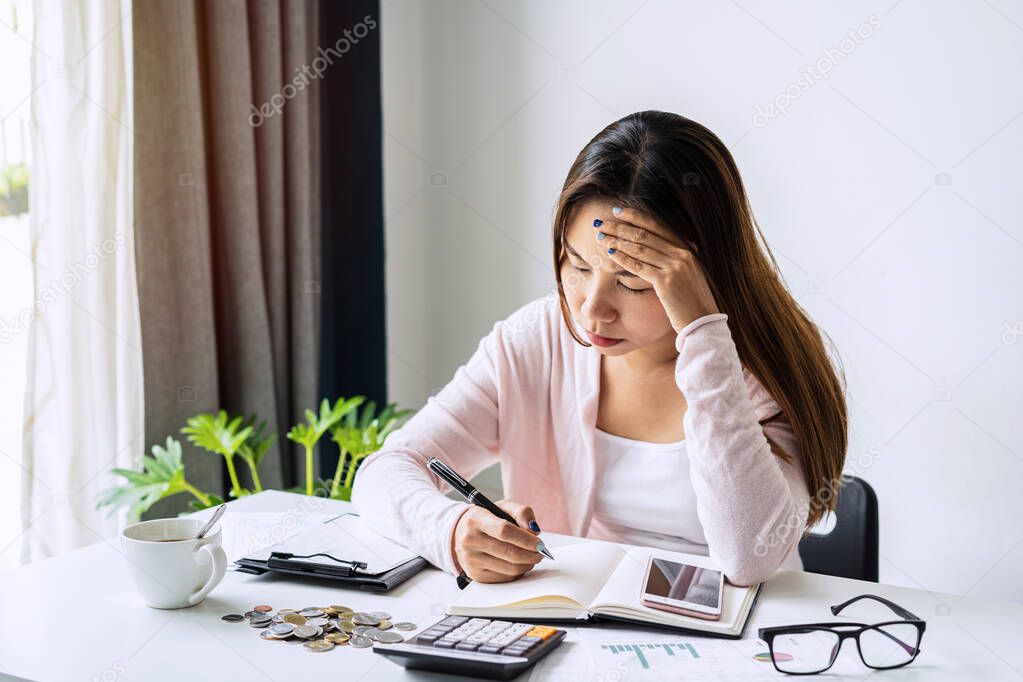 Stressed young woman calculating monthly home expenses, taxes, bank account balance and credit card bills payment, Income is not enough for expenses.