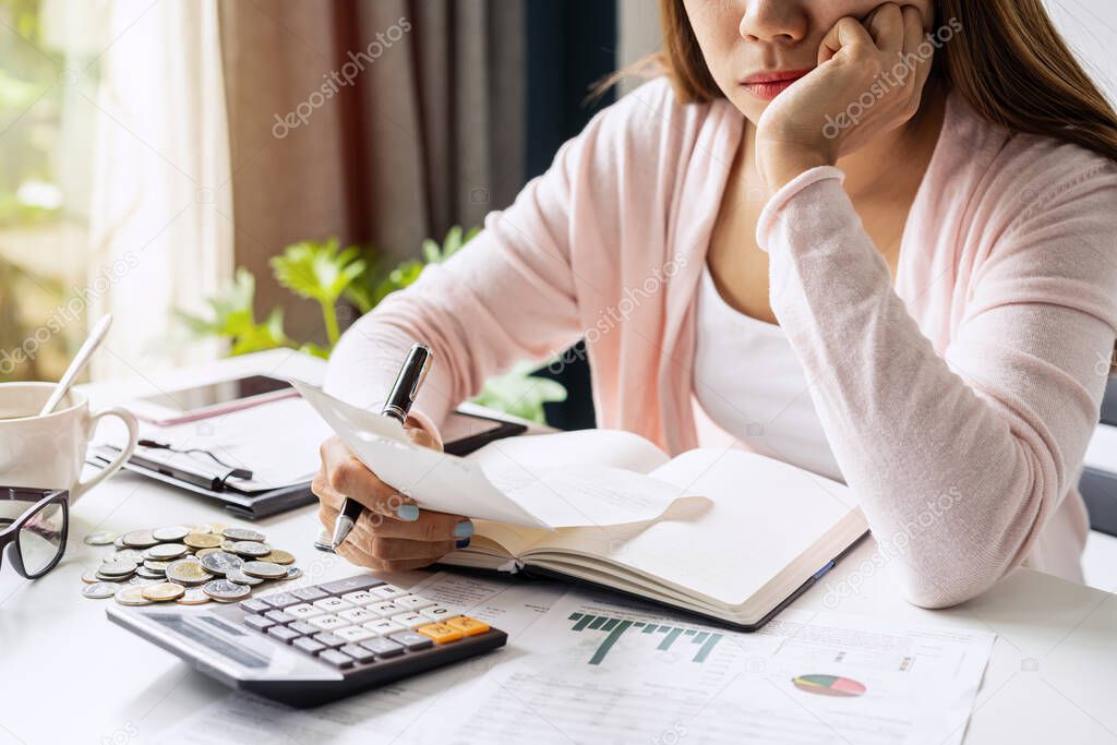 Stressed young woman calculating monthly home expenses, taxes, bank account balance and credit card bills payment, Income is not enough for expenses.