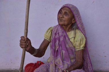 Narsinghpur, Madhya Pradesh / Hindistan: 14 Mayıs 2020 - Kırsal alanda yürümek için elinde sopa tutan geleneksel bir Hintli kadın