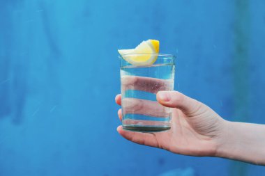 Fema el limonlu su bardağı tutuyor.