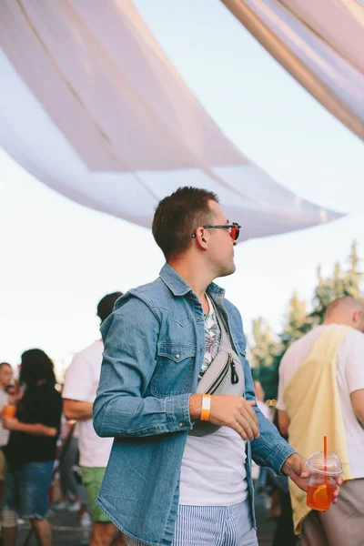 Hip man standing out for the crowd in the festival and enjoying the music