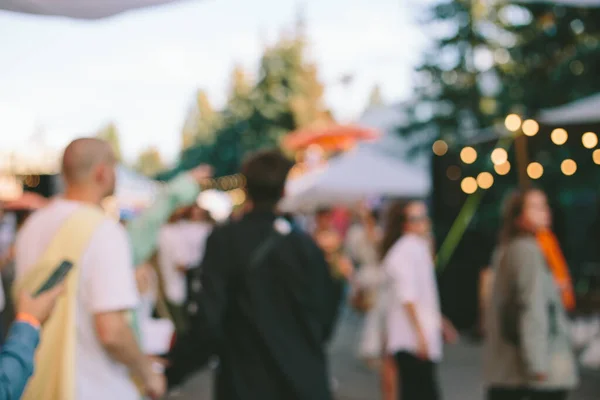 Blur defocused background of people in park fair, summer festival, family outdoors, festive fair