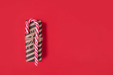 Kırmızı arkaplanda soyulmuş bir hediye kutusu, sıfır atık Noel konsepti, metin için boşluk, üst görünüm