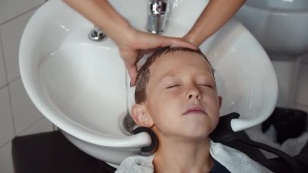面白い少年がその理髪店を訪れた。美容室でシャンプー。4K — ストック動画