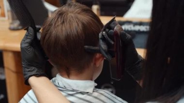 Komik bir çocuk berbere gitti. Güzel Ermeni kadın kuaför saçını kesiyor. 4K