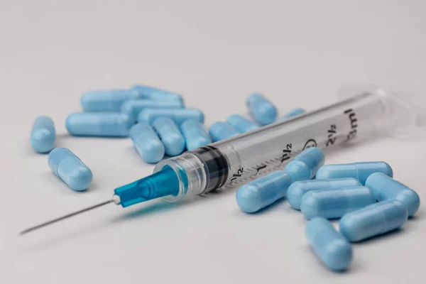 Κλείστε την όψη μιας σύριγγας με υποδόρια βελόνα και γενόσημα μπλε χάπια. Οι υπερβολικές δόσεις οπιούχων και ηρωίνης έχουν εκτοξευθεί κατά τα τελευταία έτη VI — Φωτογραφία Αρχείου