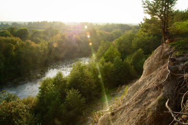 Çamur dağı, uçurum, Uralların doğası, dağ yamacında gün batımı, dağın eteğinde nehir, beyaz dağ