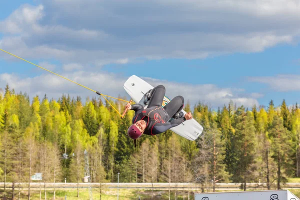 Fagersta スウェーデン 2020年5月26日 ウェイクボード10代の女の子がウェイクボード上で極端なジャンプを行い 周りには多くのスプラッシュがあります 横になって ティーンエイジャーはヘルメットを使用しています ウェイクボードは極端なスポーツです — ストック写真