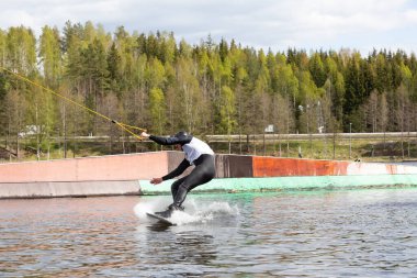Fagersta, İsveç - Maj 26, 2020: adam gölde wakeboard kullanıyor. Wakeboard ekstrem spordur.