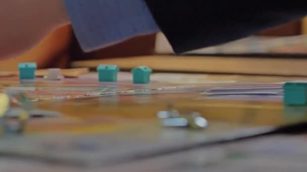 Close-up of the hands of people playing the game Monopoly. — Stock Video
