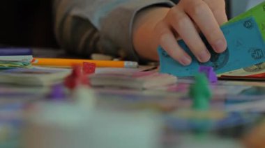 Monopoly oynayan insanların ellerini yakın plan çekeceğiz..