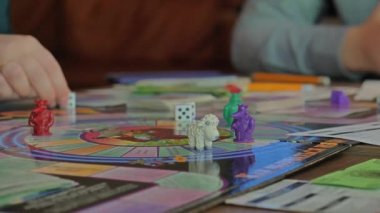 Monopoly oynayan insanların ellerini yakın plan çekeceğiz..