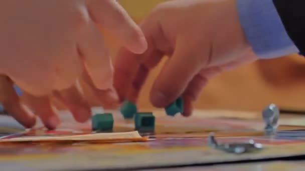 Gros plan sur les mains des gens qui jouent au jeu Monopoly. — Video