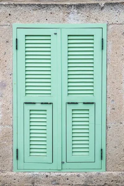 石墙上的绿松石窗百叶窗 — 图库照片