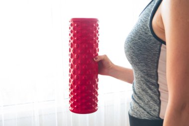 Kırmızı köpük silindiri tutan kadın..