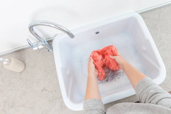 Las manos femeninas lavando ropa de color en el fregadero —  Fotos de Stock