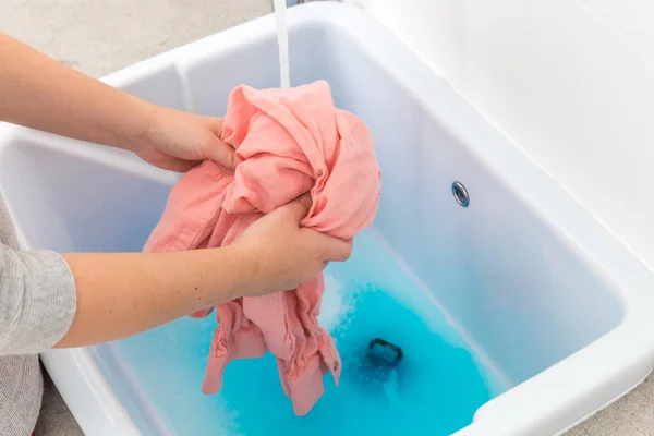 Frauenhände waschen farbige Kleidung im Waschbecken — Stockfoto