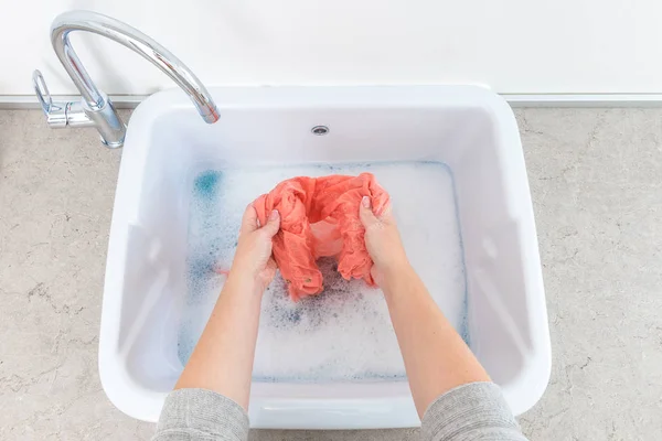 Female hands washing color clothes in sink — Stock Photo, Image