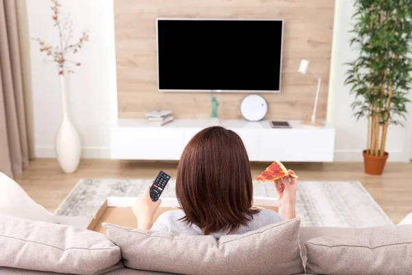 Pizza yemek ve tv izlerken tek kadın — Stok fotoğraf