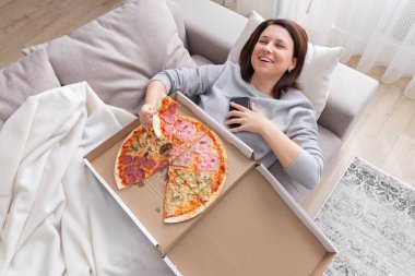 Yukarıdan çekilmiş pizza yiyen kadın