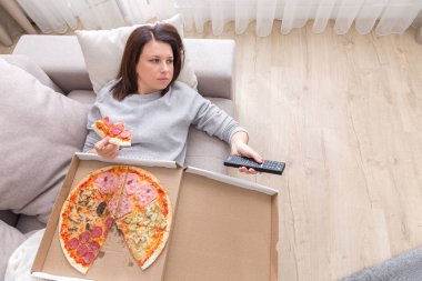 Yukarıdan çekilmiş pizza yiyen kadın