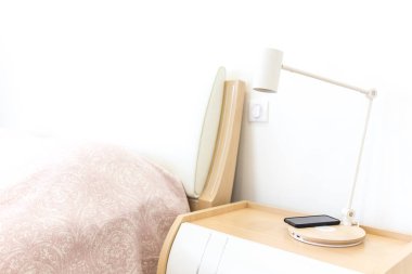 Kablosuz smartphone üzerinde yatak yakınındaki lamba şarj