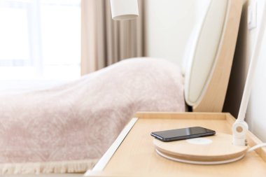 Kablosuz smartphone üzerinde yatak yakınındaki lamba şarj