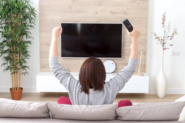 Joven feliz mujer viendo emocionada televisión fútbol deporte partido o concurso de televisión —  Fotos de Stock