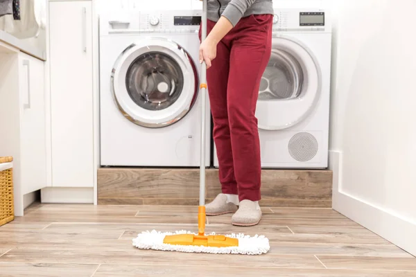 Cleaning floor in laundry room in modern house