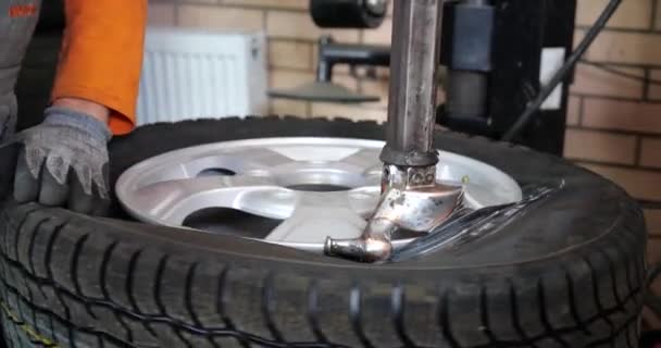 El hombre de Sservice puso en neumático en rueda del coche por la herramienta especial, mecánico usando la herramienta de montaje para la reparación de neumáticos — Vídeos de Stock