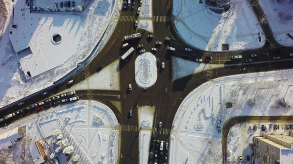 Vista abajo de la intersección en invierno, cruce de círculos con el tráfico y la nieve — Foto de Stock