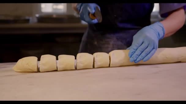 Nahaufnahme des Teiges, der in kleine Portionen geschnitten wird. roher Teig zum Backen — Stockvideo