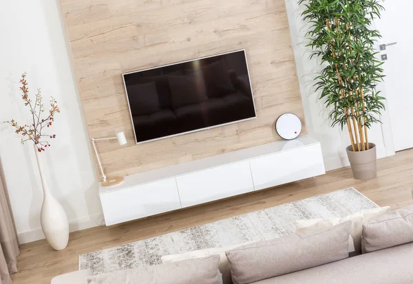 Living room with couch and led tv on wooden wall