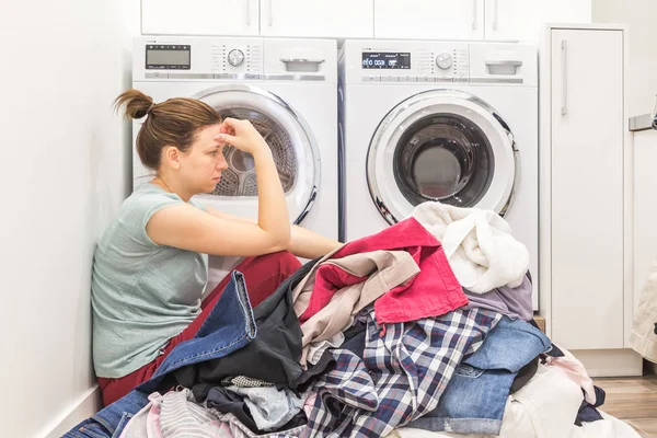 Жінка в спальні сидить на підлозі з брудним одягом — стокове фото